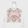 A hooded windbreaker jacket with a light pink floral front panel, white sleeves and hood, and black script text reading &
