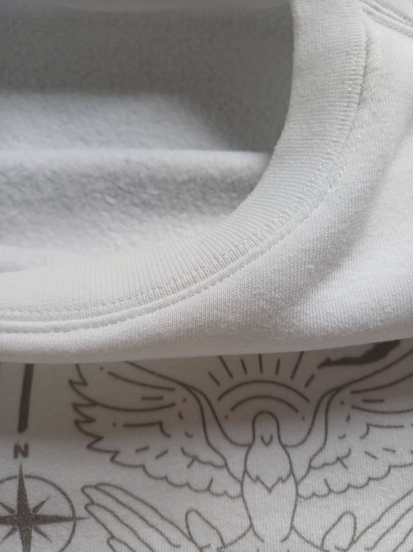 Close-up of  white faith sweatshirt collar with fleece fabric inside and dove graphic