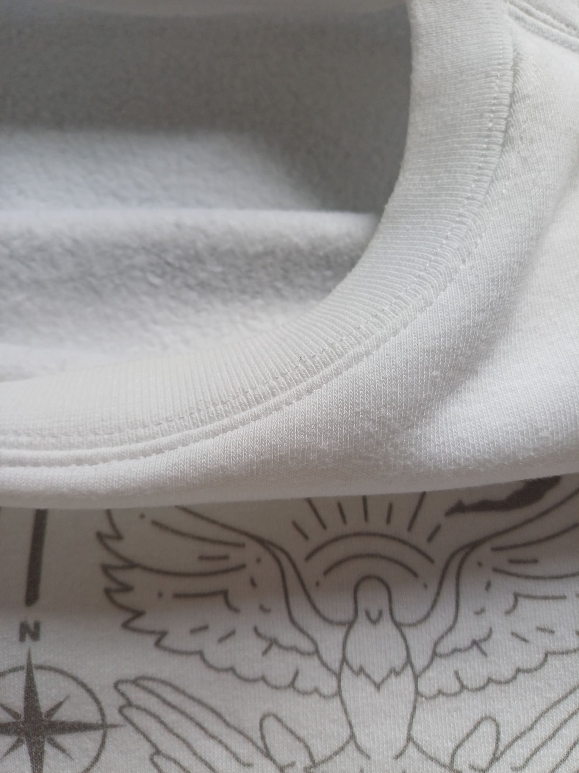 Close-up of  white faith sweatshirt collar with fleece fabric inside and dove graphic
