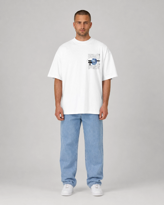 Man wearing a white t-shirt with a graphic design and light blue jeans on a gray background