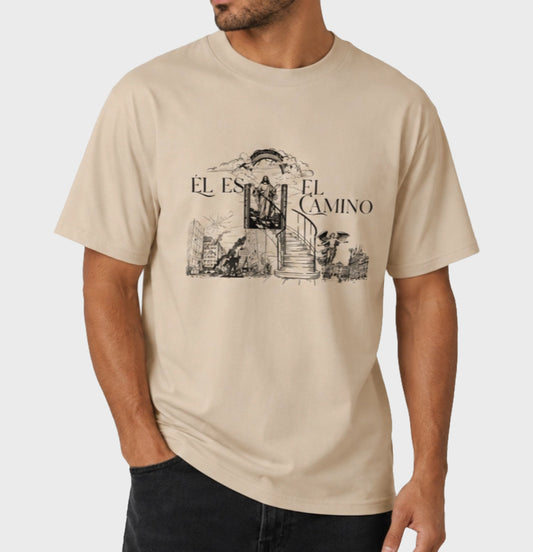 Beige t-shirt with 'El Camino' graphic design worn by a person on a light gray background