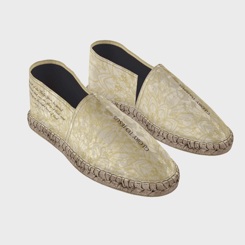 Pair of beige espadrilles with floral pattern on a light gray background