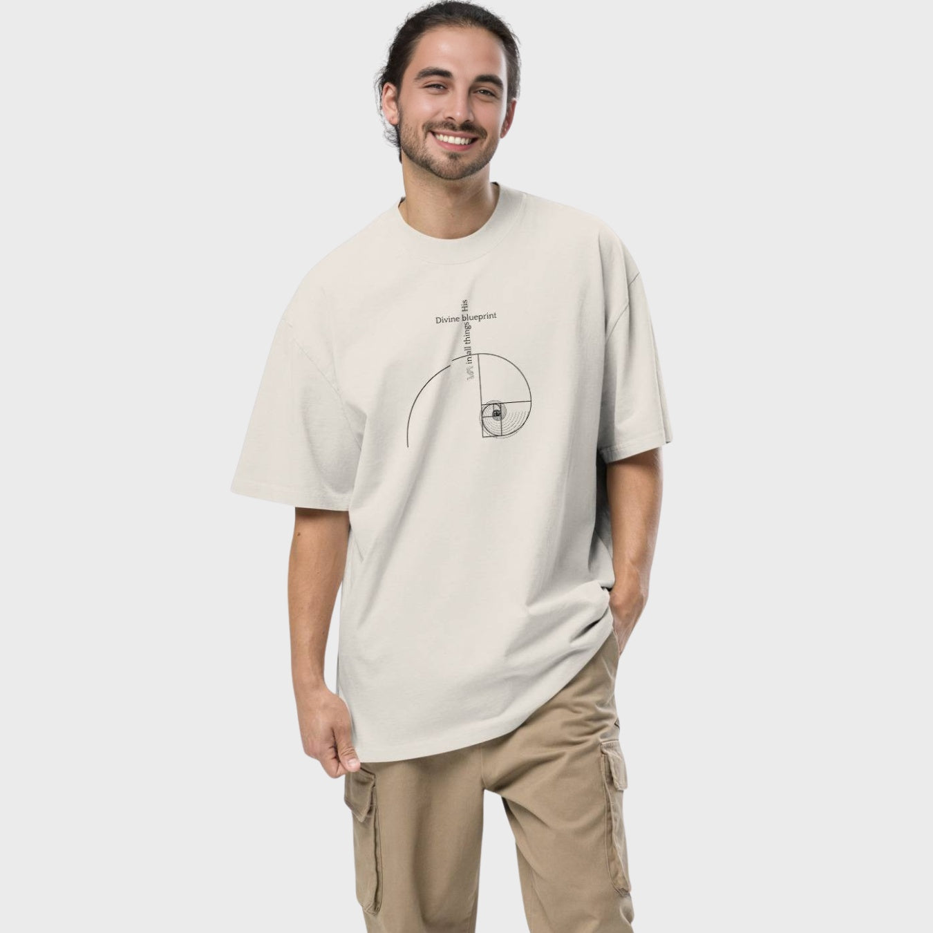 Man wearing a beige t-shirt with a graphic design on a white background