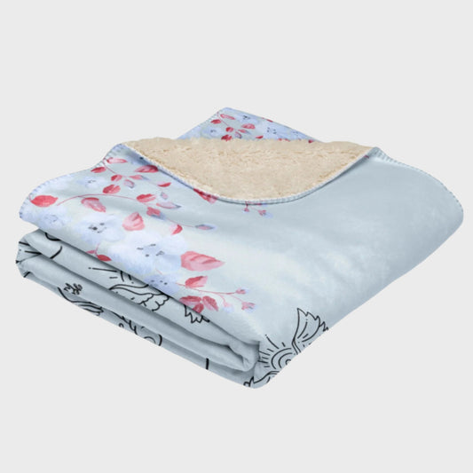 Folded light blue blanket with flower elements 