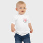 Baby wearing a white t-shirt with a heart design and text on a plain background