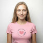 Person wearing a pink t-shirt with a heart design and text on a plain 