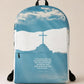 A medium-sized backpack featuring a blue sky with a cross and clouds design, and a quote from the Bible.
