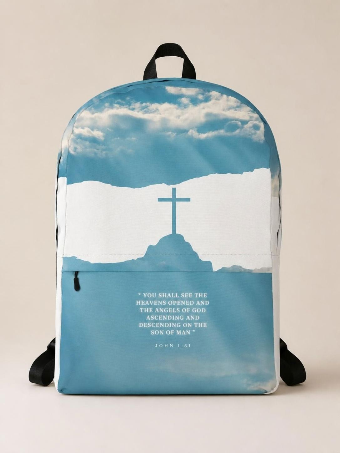A medium-sized backpack featuring a blue sky with a cross and clouds design, and a quote from the Bible.