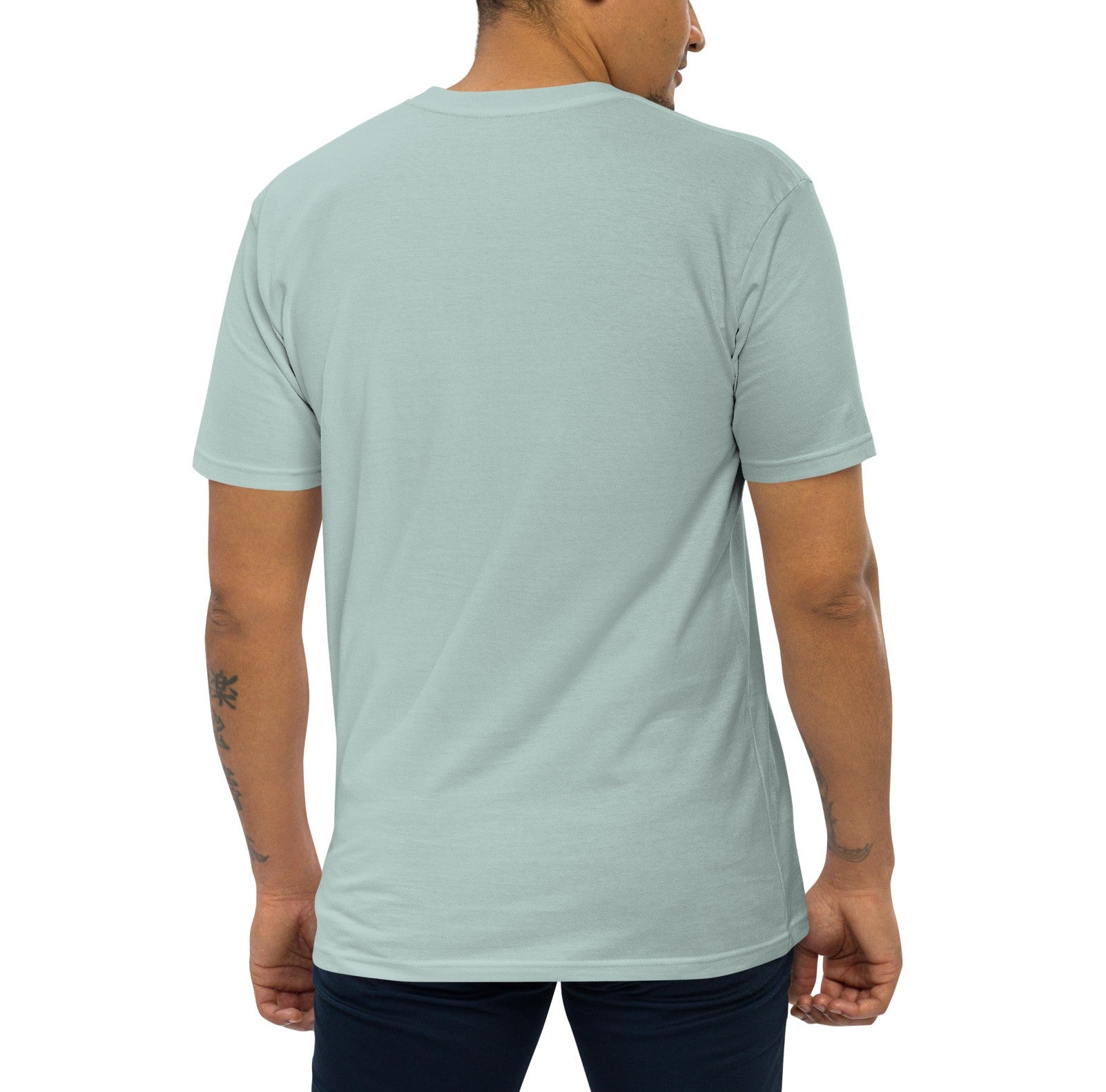 Man wearing agave colored shirt from behind on plain background