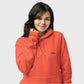 Person wearing an orange hoodie with a logo on a light gray background
