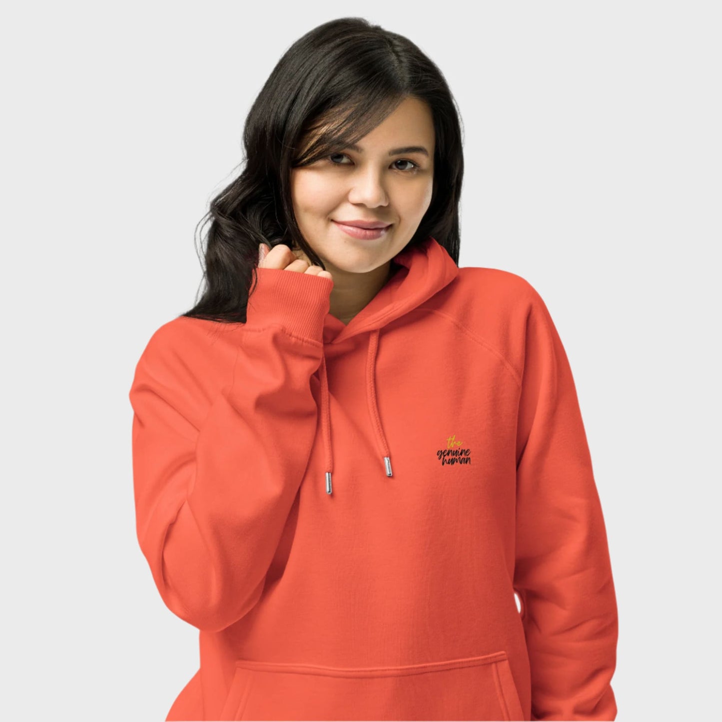 Person wearing an orange hoodie with a logo on a light gray background