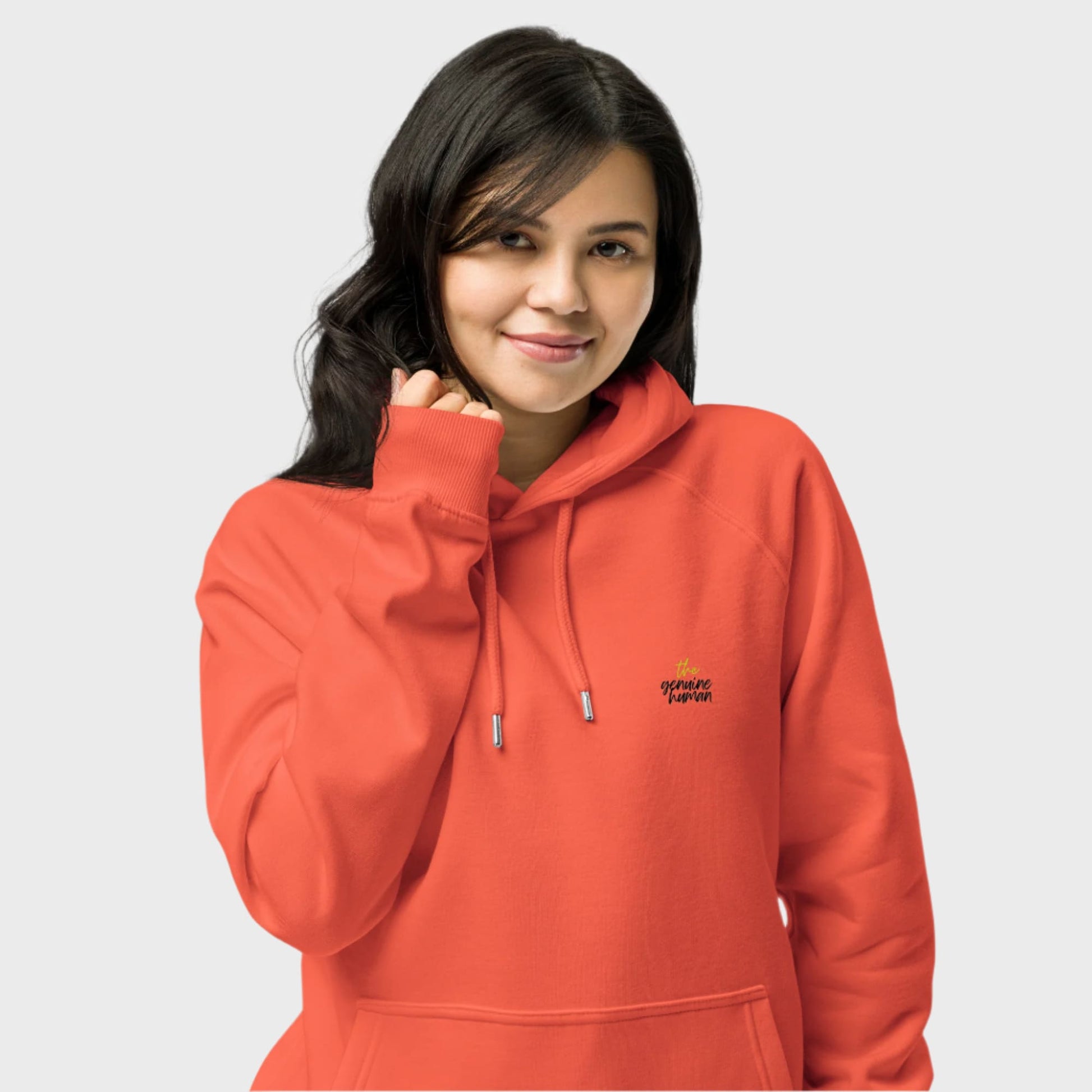 Person wearing an orange hoodie with a logo on a light gray background