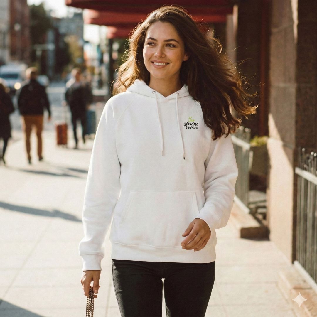 Woman wearing a white hoodie with a logo on a city street