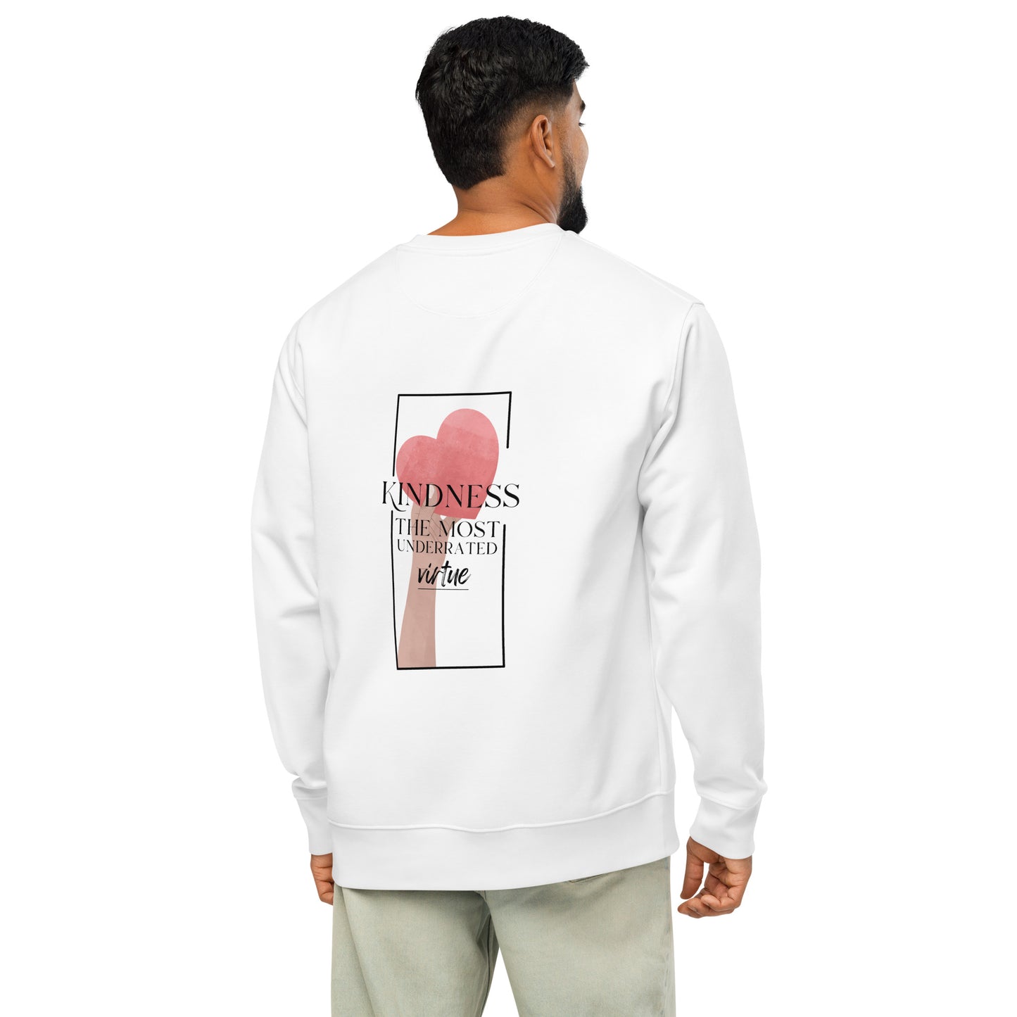 A man viewed from the back wearing a white crewneck sweatshirt with a graphic print on the back featuring a pink heart and the text 'KINDNESS THE MOST UNDERRATED VIRTUE'.