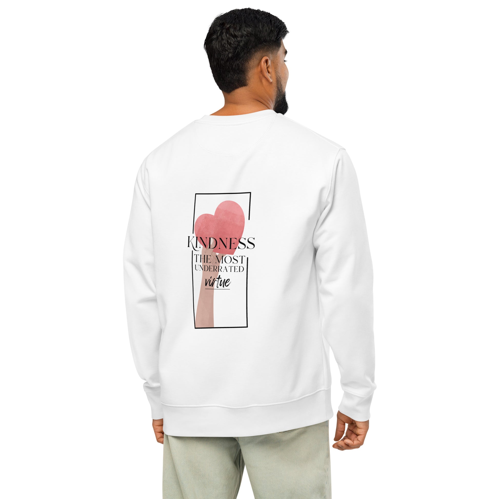 A man viewed from the back wearing a white crewneck sweatshirt with a graphic print on the back featuring a pink heart and the text 'KINDNESS THE MOST UNDERRATED VIRTUE'.