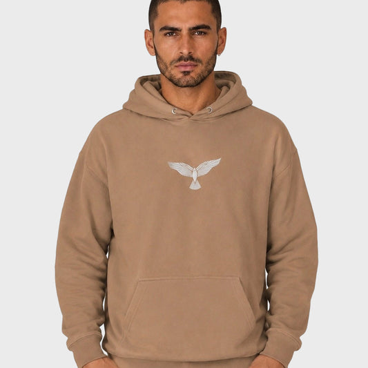 Man wearing a brown hoodie with an eagle logo on a white background