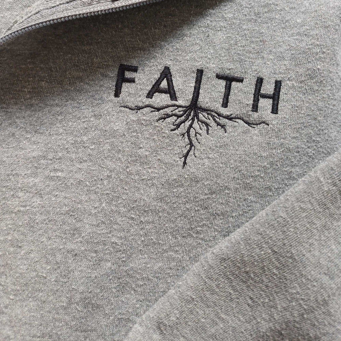 Grey hoodie with 'FAITH' and root design embroidered on it