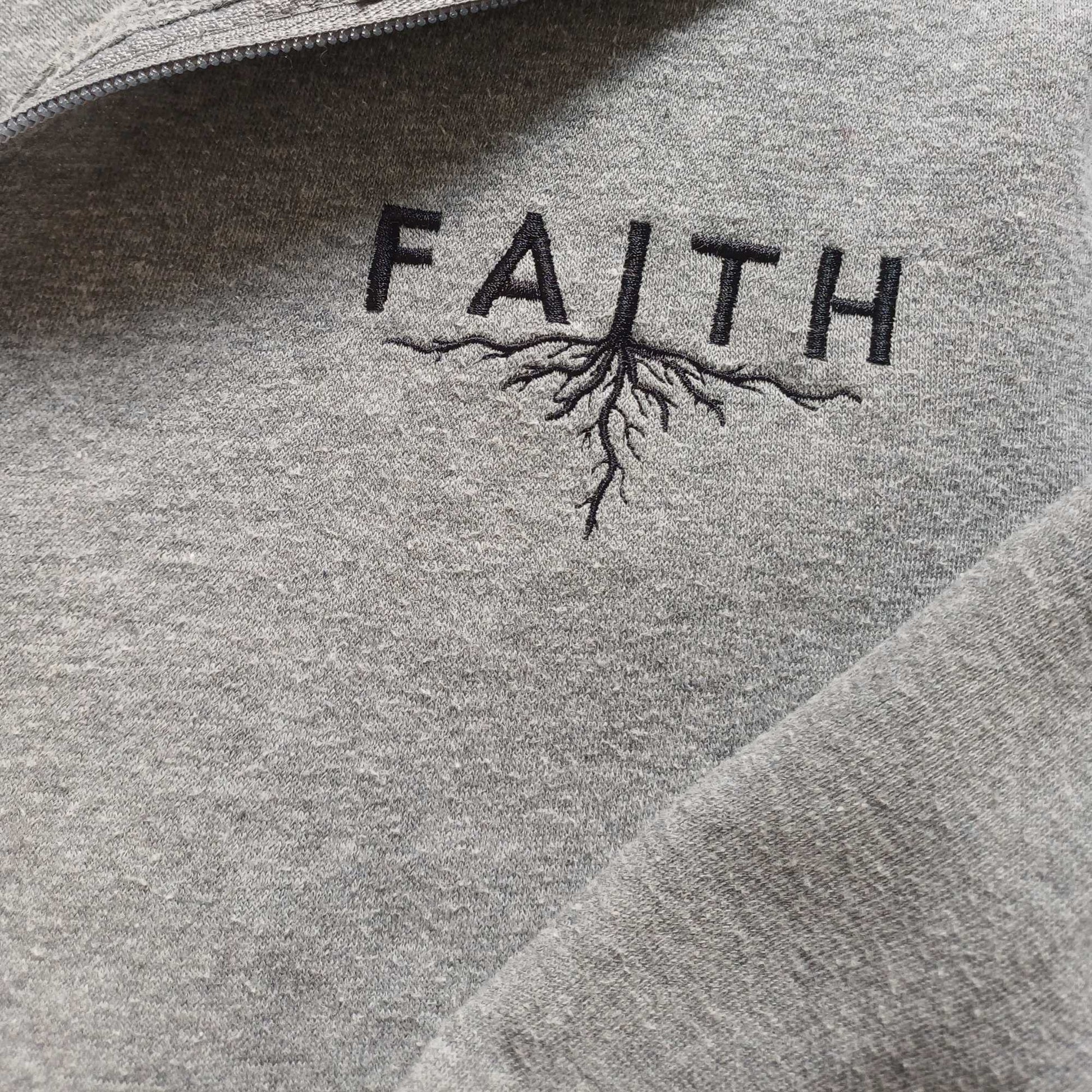 Grey hoodie with 'FAITH' and root design embroidered on it