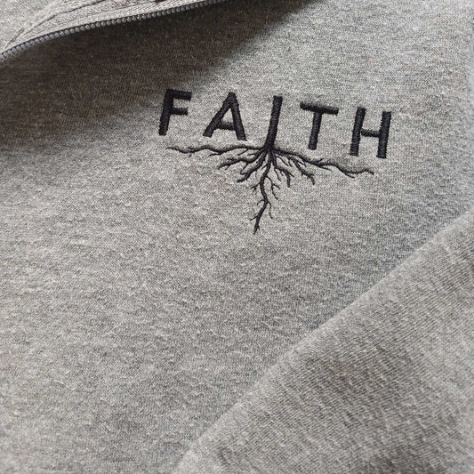 Grey hoodie with 'FAITH' and root design embroidered on it
