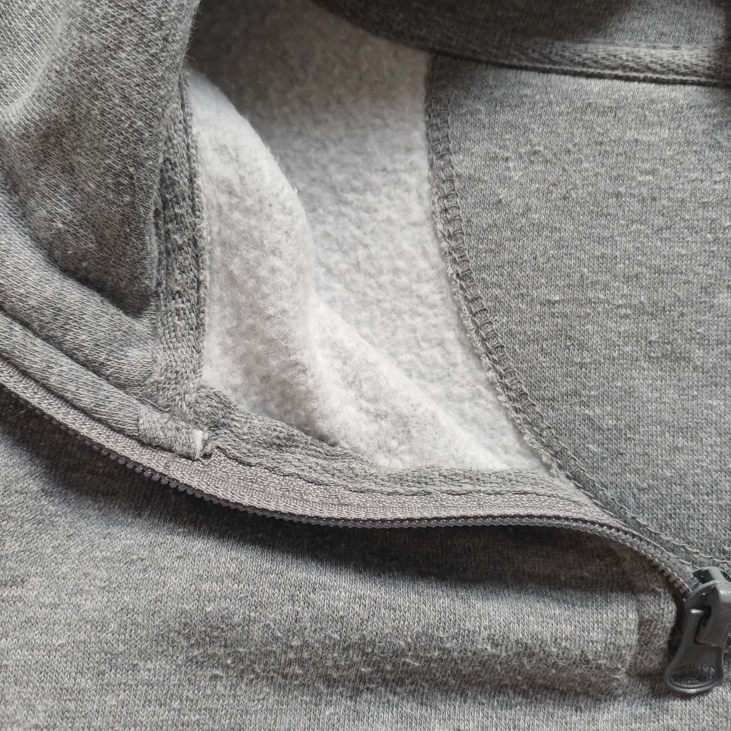 Close-up of a gray fleece jacket with a zipper