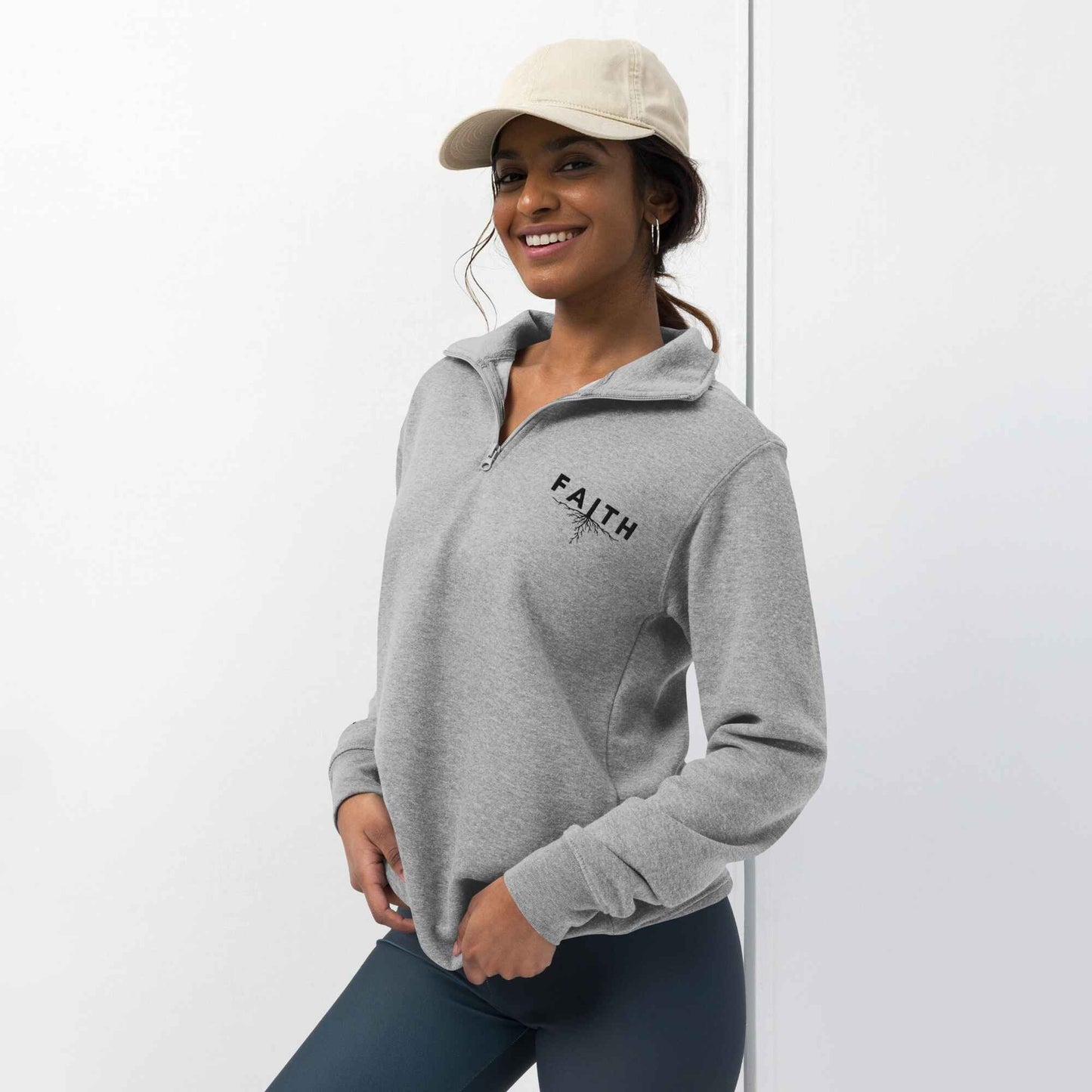 Woman wearing a gray hoodie with 'FAITH' printed on it against a white background