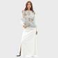 Woman wearing a floral top and white skirt on a plain background