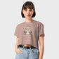 Person wearing a beige t-shirt with a graphic design on a plain background