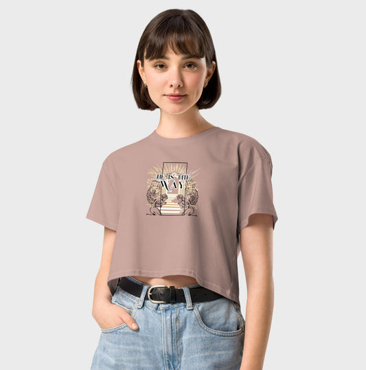 Person wearing a beige t-shirt with a graphic design on a plain background