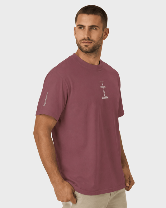 Man wearing a maroon t-shirt with a logo on a light gray background