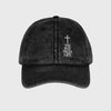 Black cap with a cross and text on a light gray background
