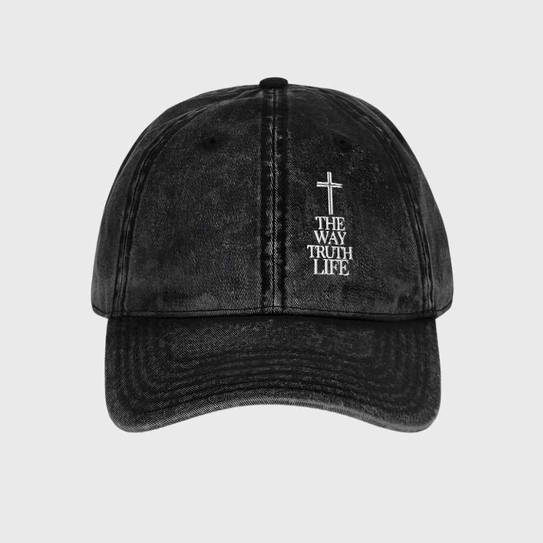 Black cap with a cross and text on a light gray background