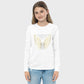 Girl wearing a white long-sleeve shirt with gold wings and text on a plain background