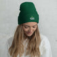 Woman wearing pine green beanie hat with text thegenuinehuman