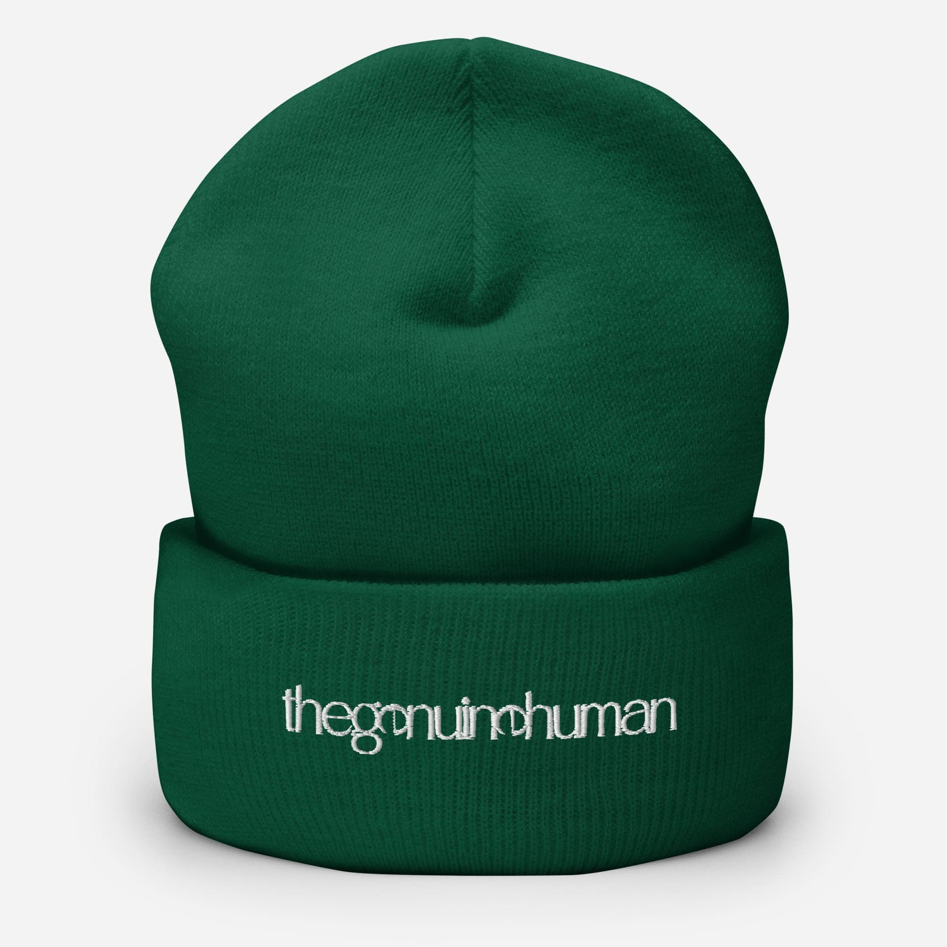 Green beanie with 'the genuine human' text on a white background