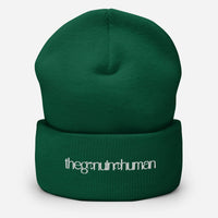 Green beanie with 'the genuine human' text on a white background
