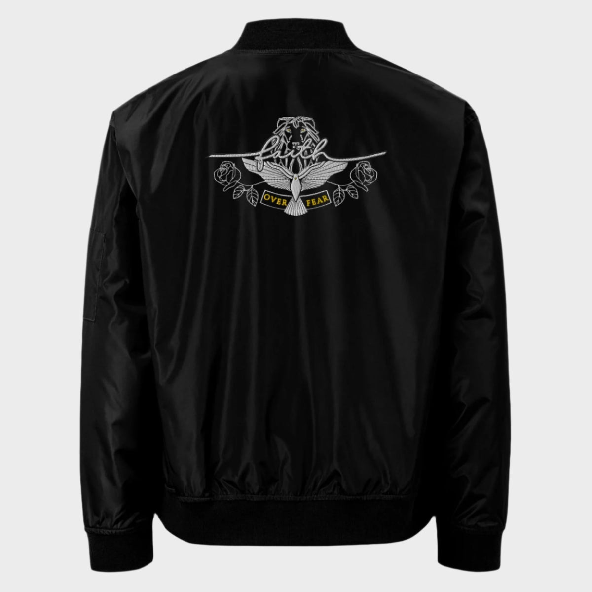 A black sustainable bomber jacket with 'faith over fear' text and an embroidered animal head, dove, and roses design on the back.